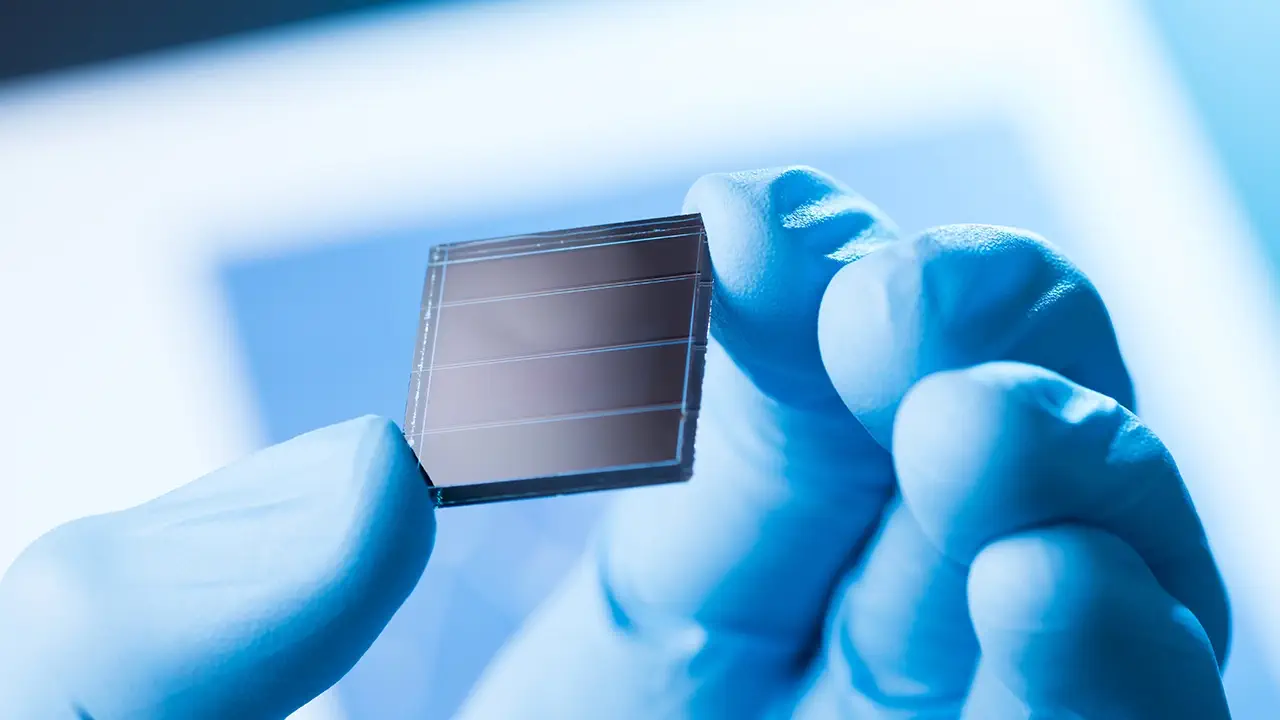 A solar cell is being held.
