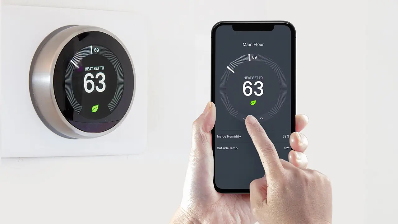 A smart thermostat is being operated using a smartphone.