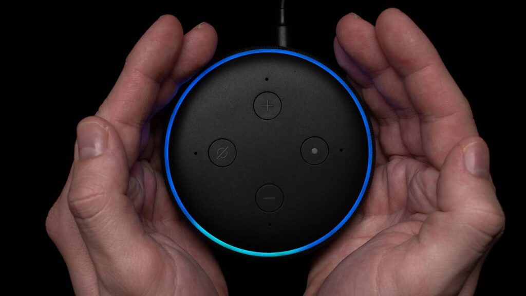 An Echo Dot is being held in a pair of hands, ready for moving.